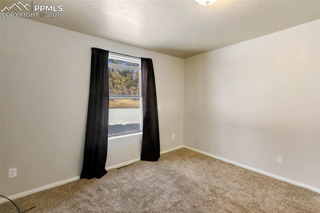 Image 9 of 36: Empty room featuring light colored carpet and baseboards