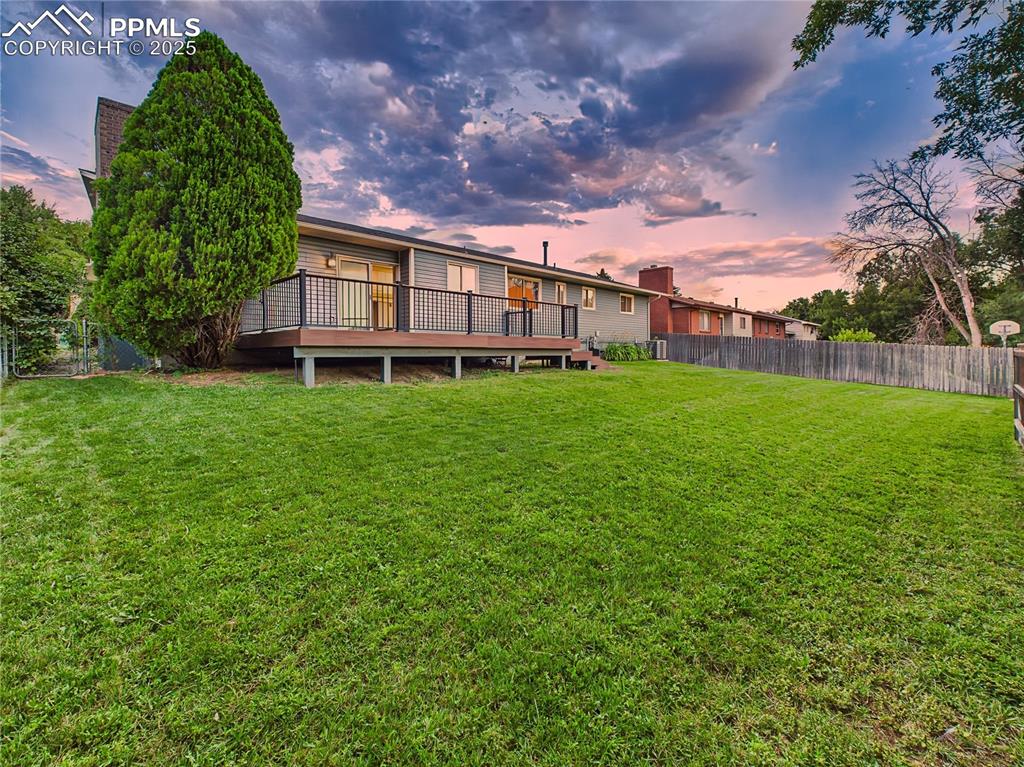 Image 42 of 49: Backyard Overview – Expansive, fully fenced backyard with two gates and mat