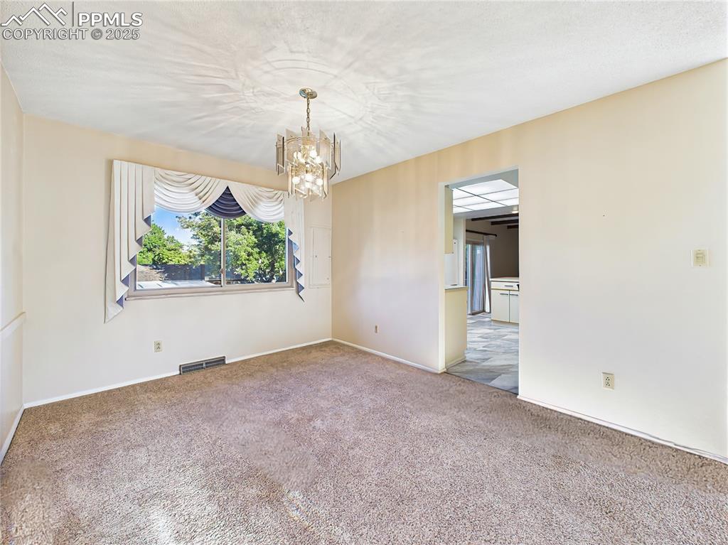 Image 7 of 49: Formal Dining Room (Empty, Kitchen View) – The formal dining room features