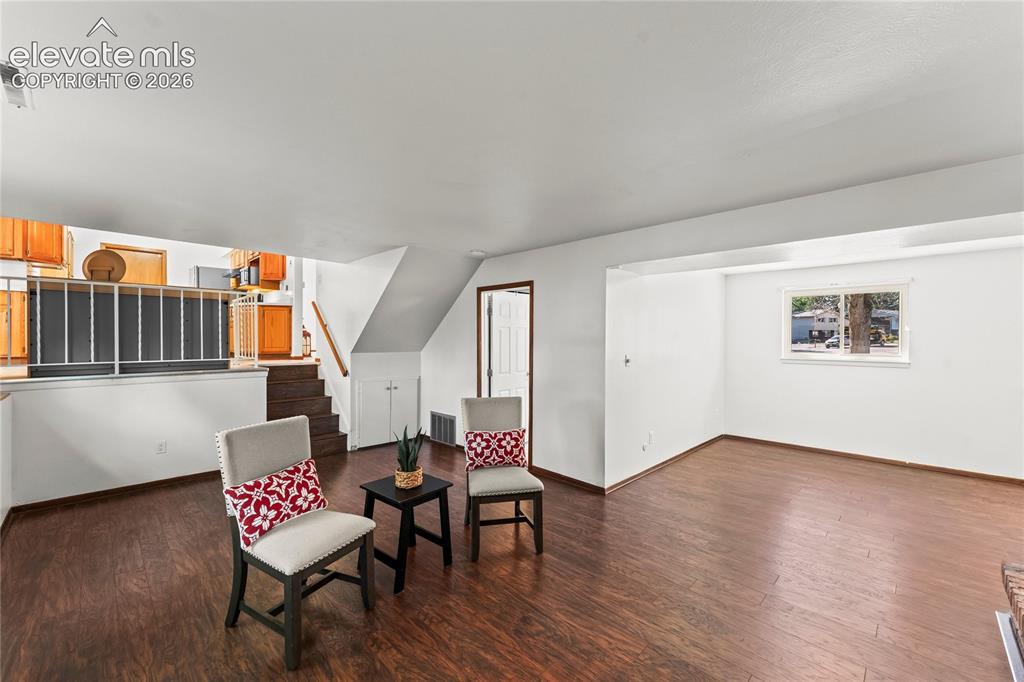 Image 14 of 45: Bright interior with wood-finish flooring extending through an open doorway