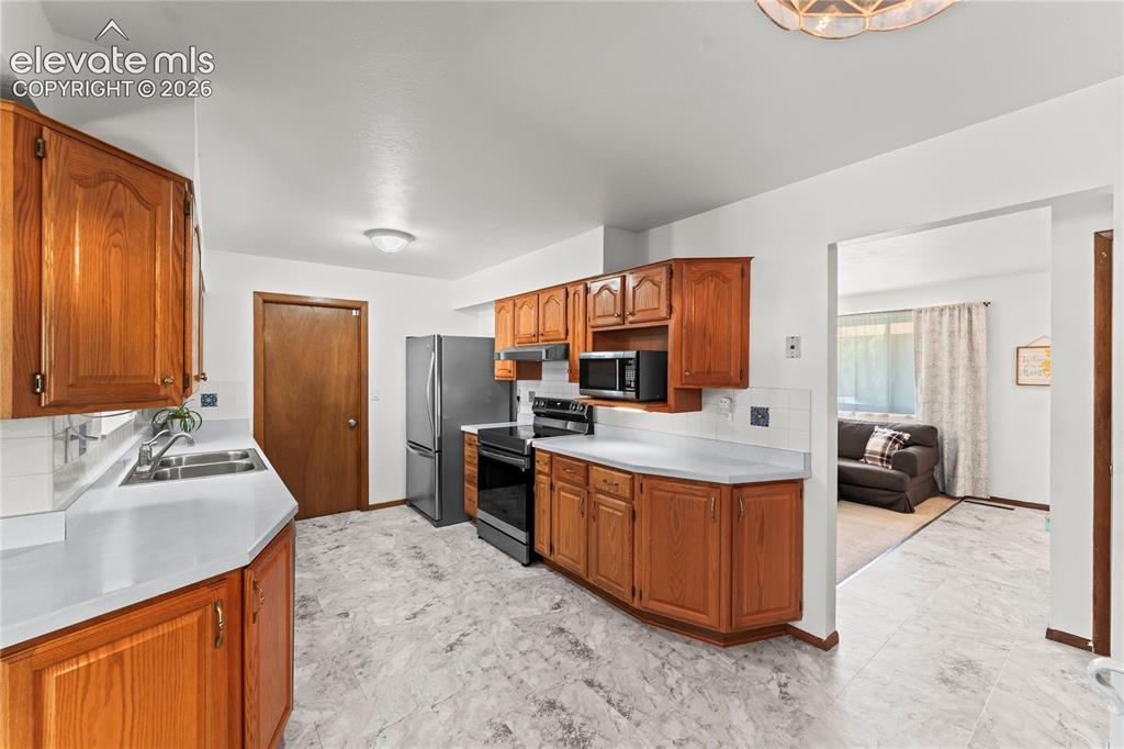 Image 8 of 45: Wide galley kitchen with LVT flooring