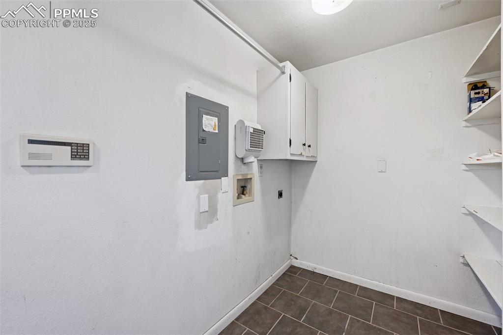 Image 14 of 33: Washroom with cabinet space, hookup for an electric dryer, electric panel, 