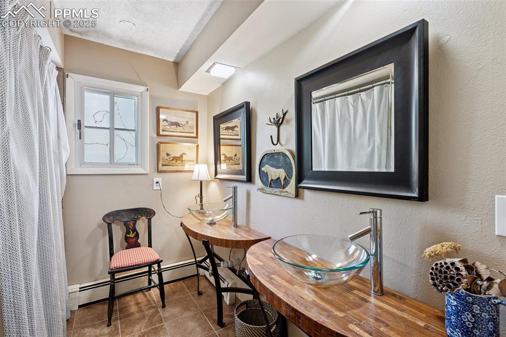 Image 22 of 33: Bathroom featuring a baseboard radiator, tile patterned floors, baseboards,