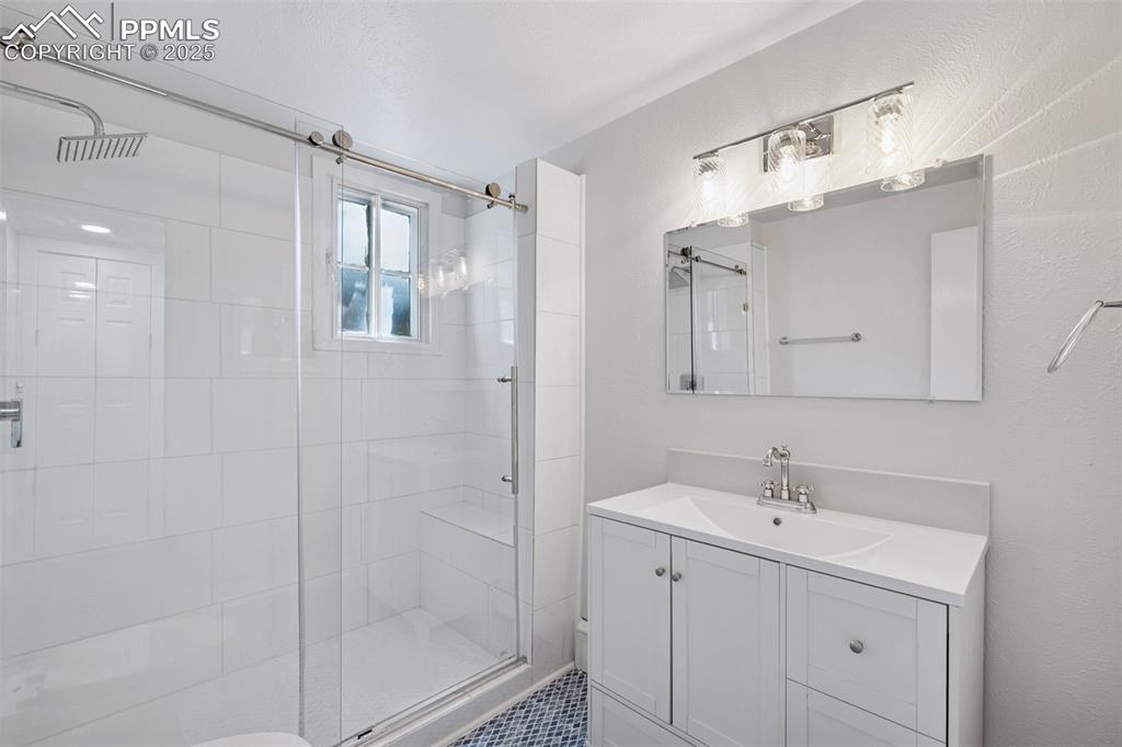 Image 30 of 33: Bathroom with a shower stall and vanity