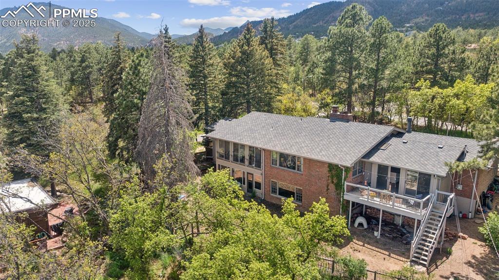Image 32 of 33: Aerial view of property and surrounding area featuring a forest and a mount