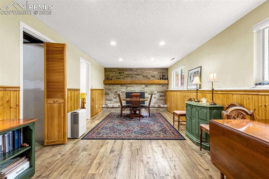 Image 11 of 33: Sitting room with wainscoting, wooden walls, wood-type flooring, and a text