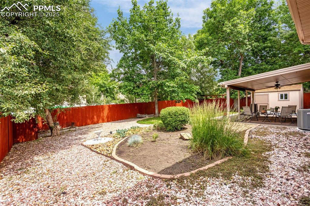 Image 23 of 33: Fenced backyard with a ceiling fan, a patio, and an outdoor hangout area