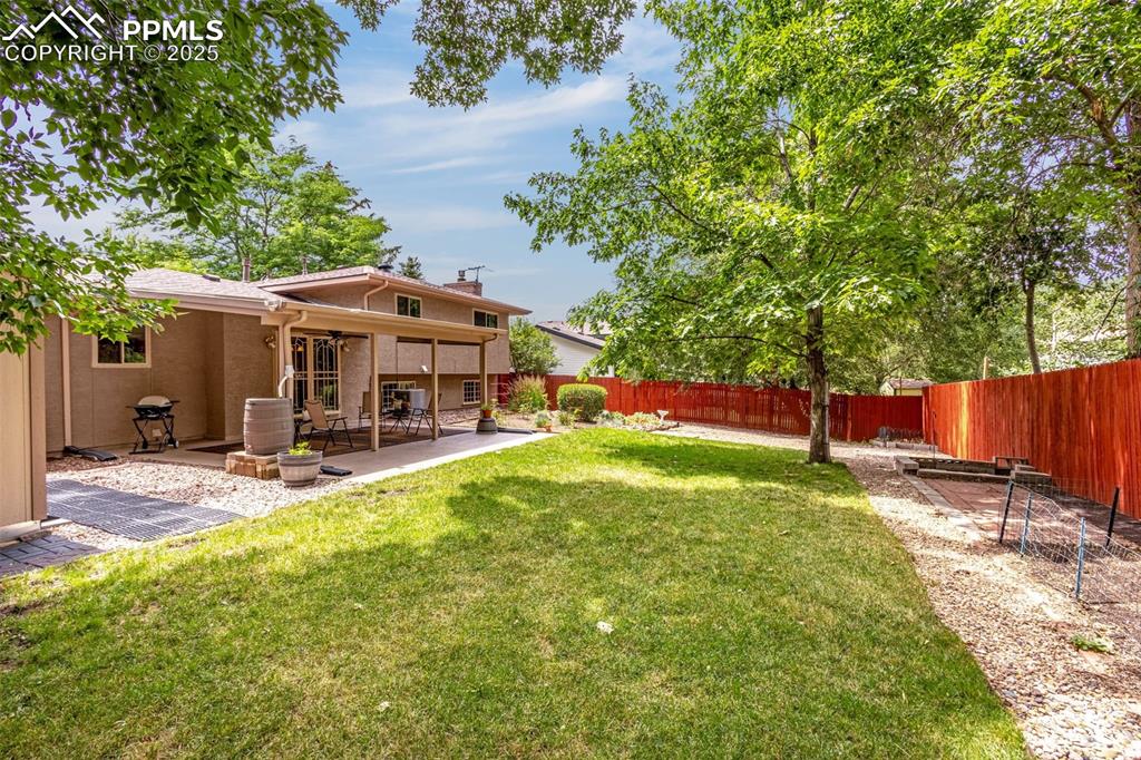 Image 25 of 33: Fenced backyard featuring a patio and a ceiling fan