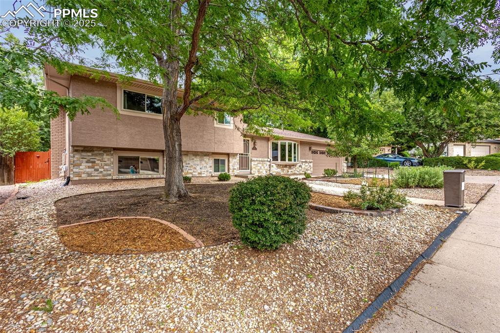 Image 3 of 33: View of front of home featuring stone siding and stucco siding