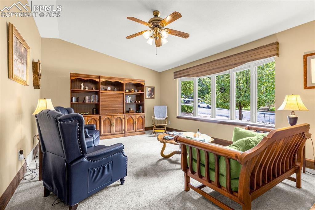 Image 4 of 33: Living room with vaulted ceiling, carpet, and a ceiling fan