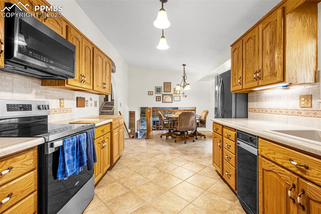 Image 8 of 33: Kitchen featuring tasteful backsplash, appliances with stainless steel fini