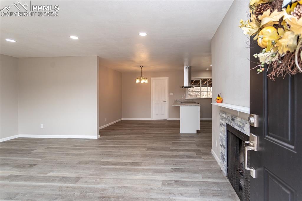 Image 4 of 50: The living area is open to the dining area and kitchen.  Notice the rock fa