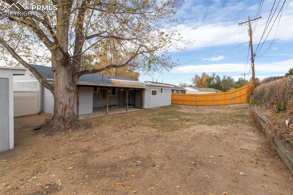 Image 45 of 50: The back yard has lots of room to run and play, and raised beds if you like