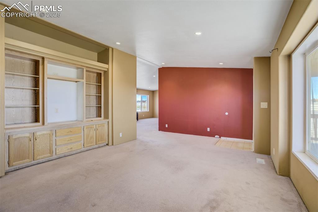 Image 12 of 50: Empty room with carpet floors, recessed lighting, and lofted ceiling