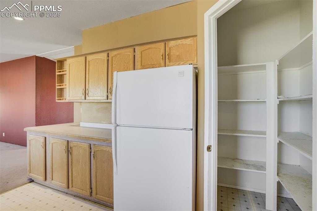 Image 20 of 50: Kitchen with recessed lighting, light countertops, freestanding refrigerato