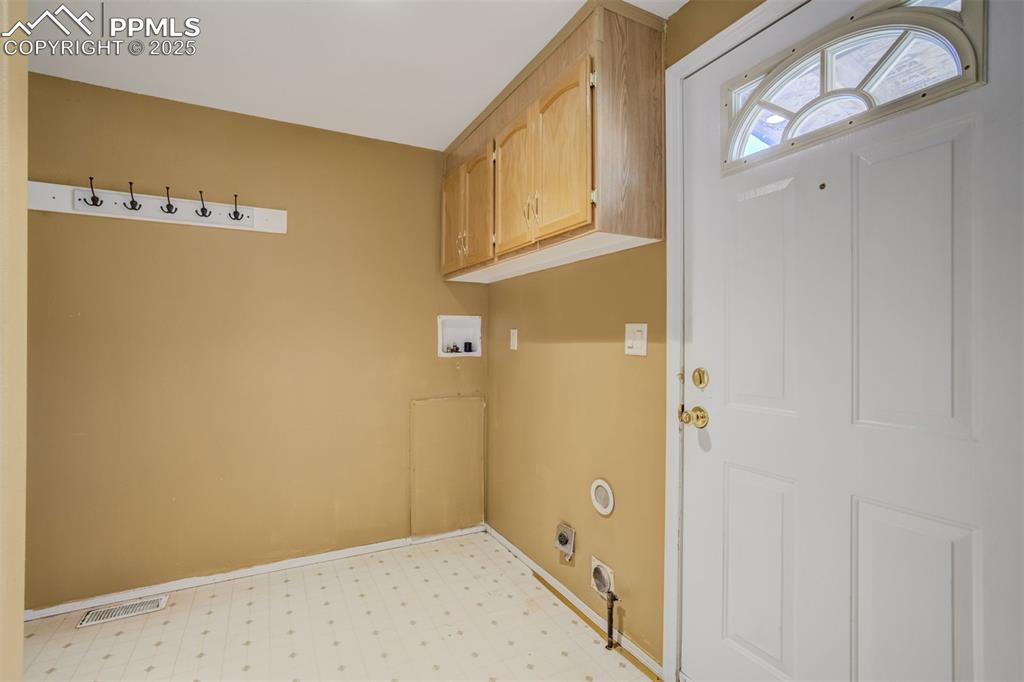 Image 21 of 50: Laundry room featuring hookup for an electric dryer, light floors, visible