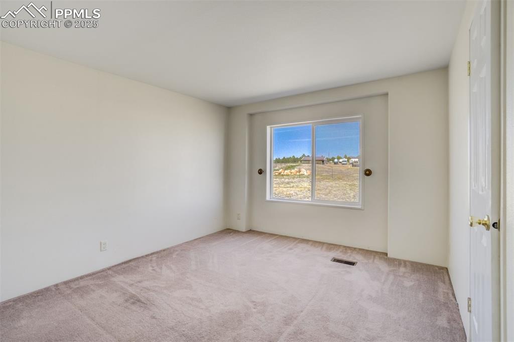 Image 28 of 50: Carpeted spare room with visible vents
