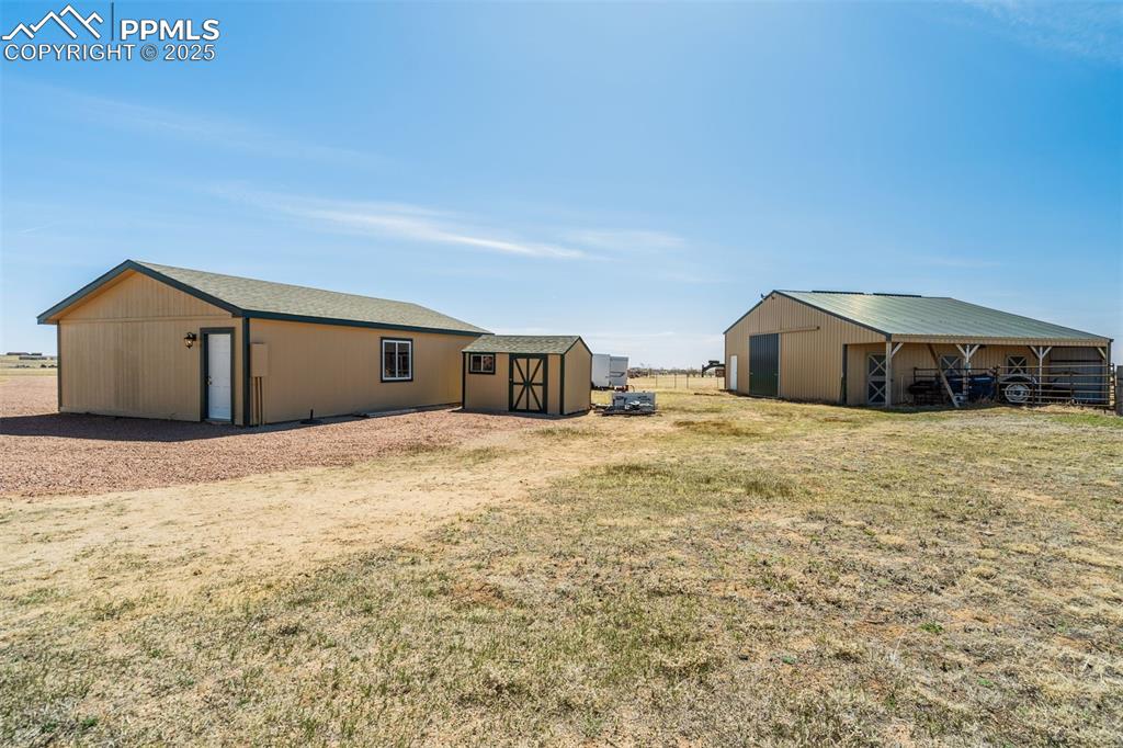 Image 35 of 50: View of yard featuring an outbuilding and a pole building