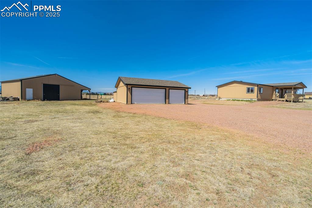 Image 4 of 50: View of yard featuring an outbuilding and a detached garage
