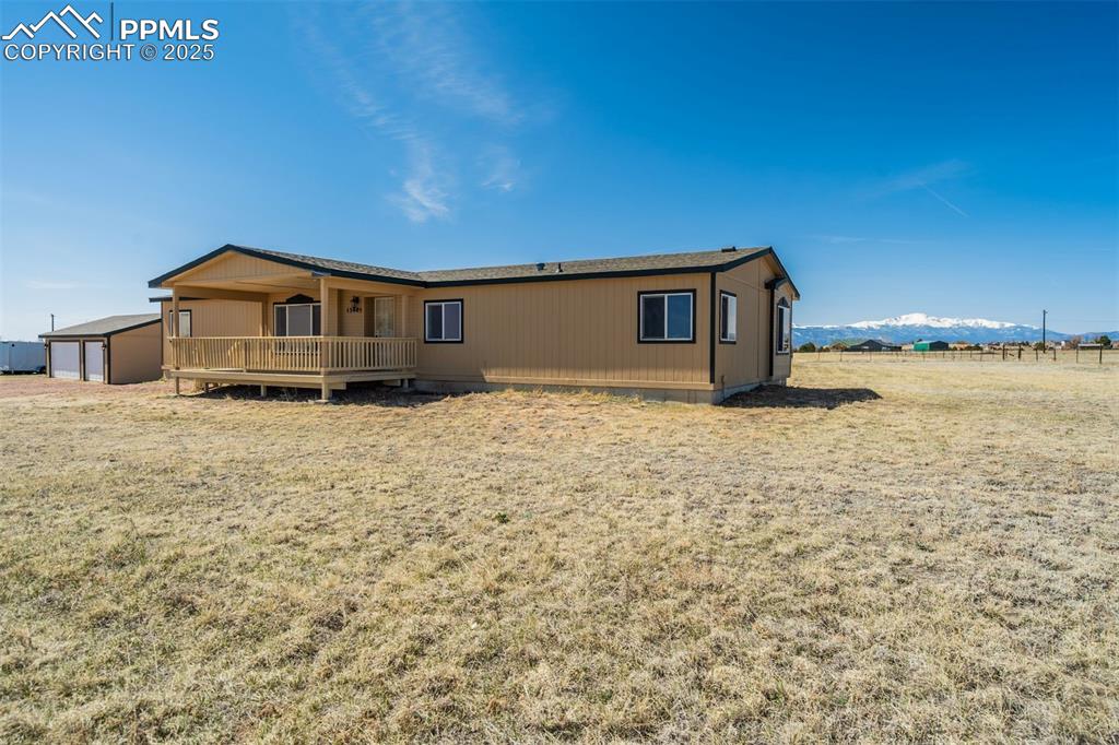 Image 6 of 50: Back of house featuring an outbuilding and crawl space