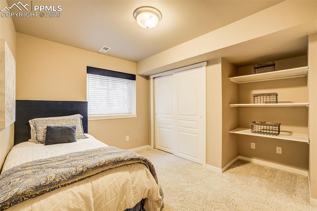 Image 40 of 50: A 6th bedroom in basement with extra shelving
