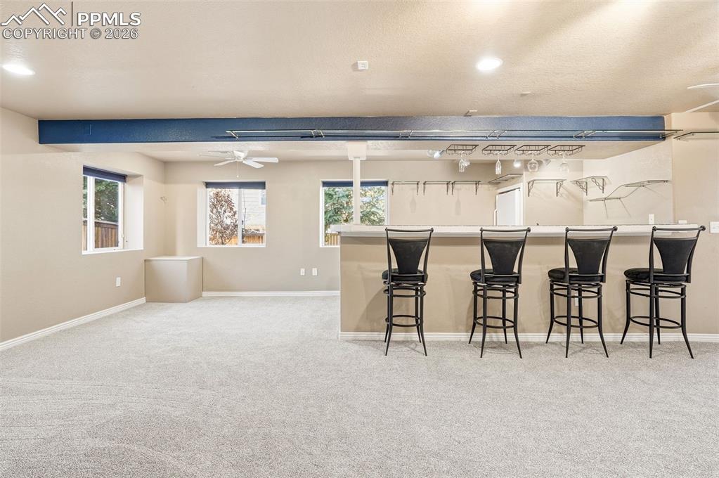 Image 24 of 36: Basement game room and wet bar area with adjacent lower deck area