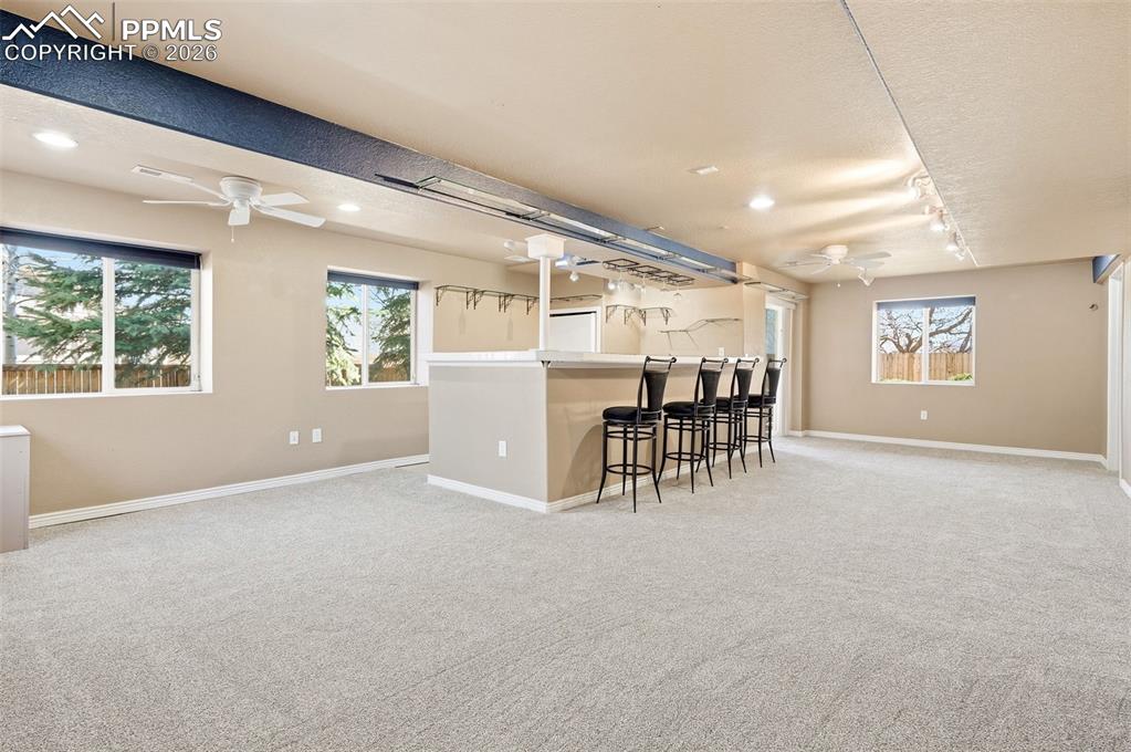Image 25 of 36: Large basement game room overlooking wet bar area