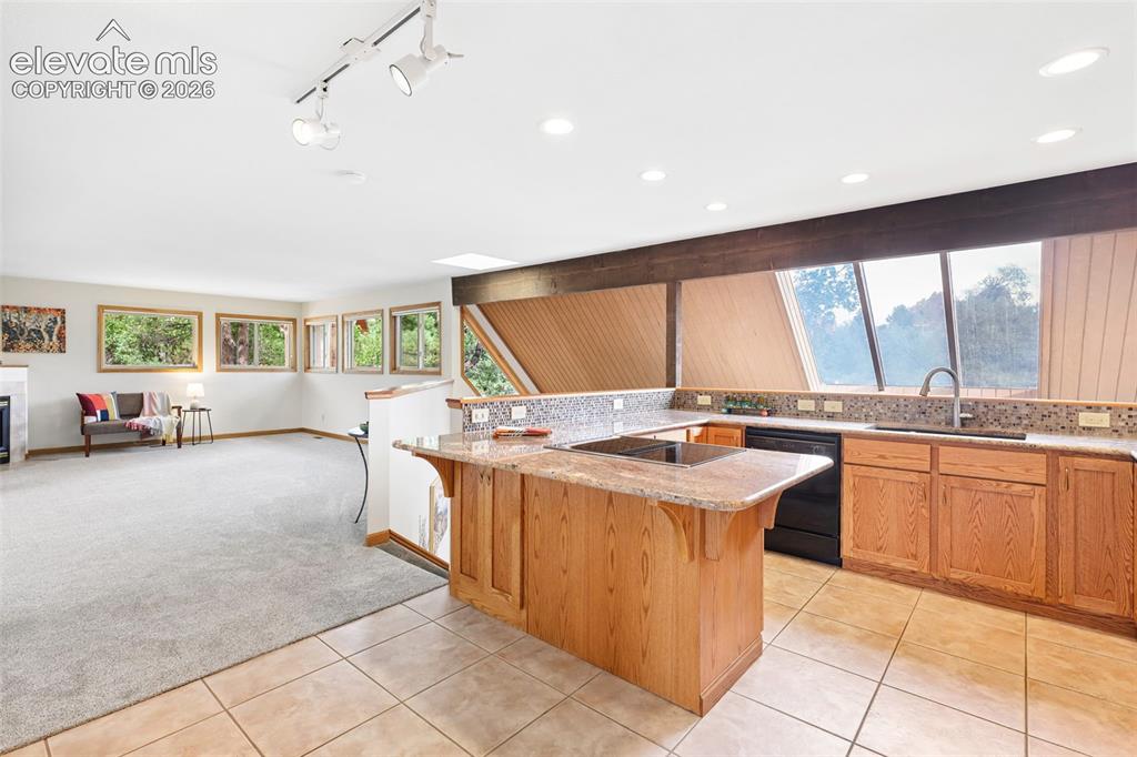 Image 12 of 41: The kitchen showcases exquisite granite, kitchen bar, and top-rated Jennair