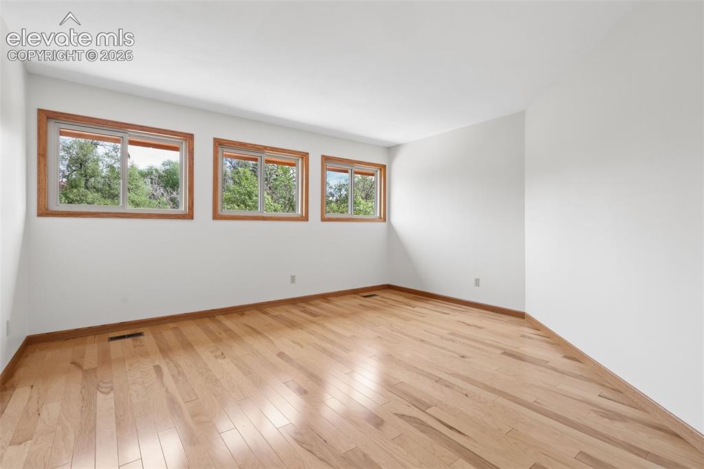 Image 18 of 41: Spacious primary bedroom with attached 3/4 remodeled bath.  Bedroom feature