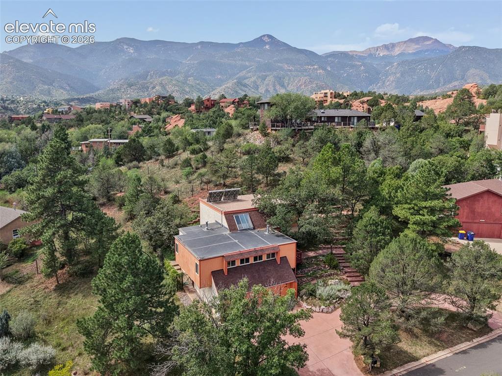 Image 2 of 41: Beautiful mature landscaping and mountain views surround this .41 acre home