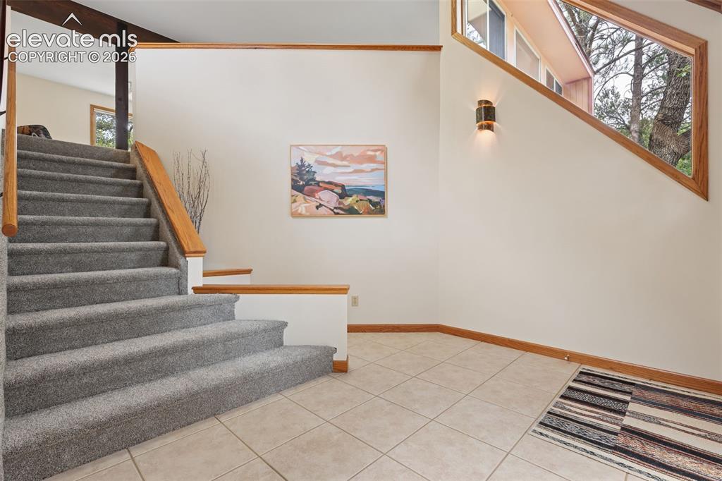 Image 7 of 41: The sweeping staircase takes you to the open concept living room, dining ro