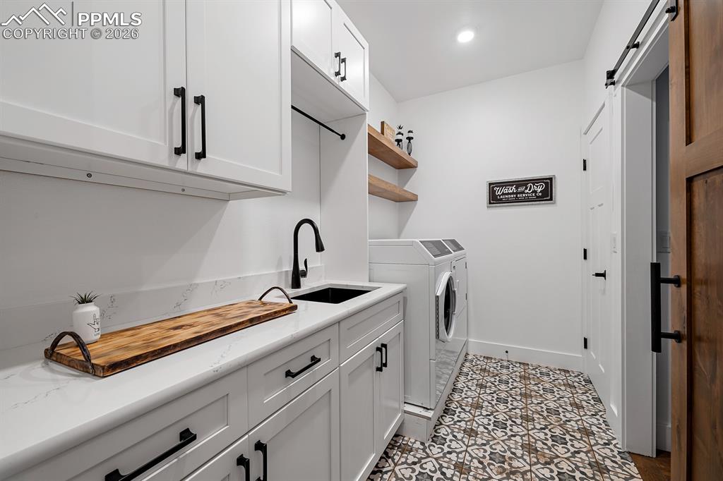 Image 18 of 30: Large laundry room with sink and storage