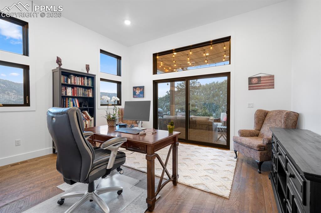 Image 21 of 30: Office with sliding doors to covered patio with tongue-and-groove ceiling a