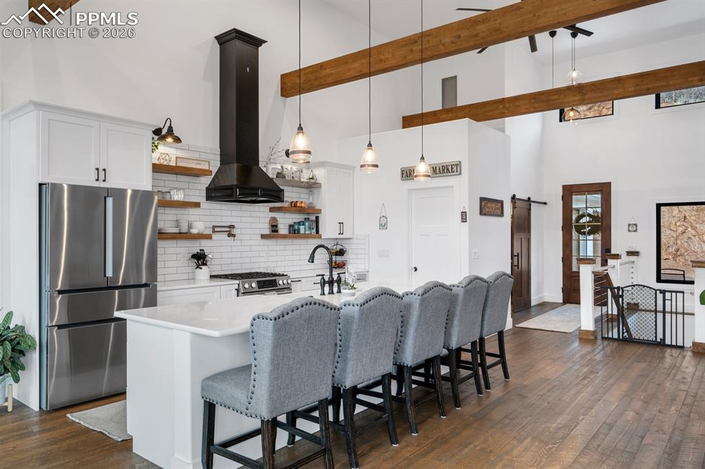 Image 7 of 30: The chef’s kitchen features Bosch appliances, black hood, quartz countertop
