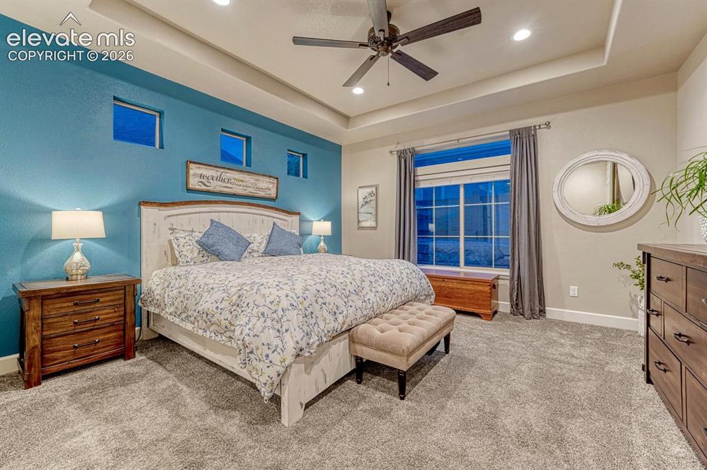 Image 12 of 44: Tray ceiling with recessed lighting and a ceiling fan