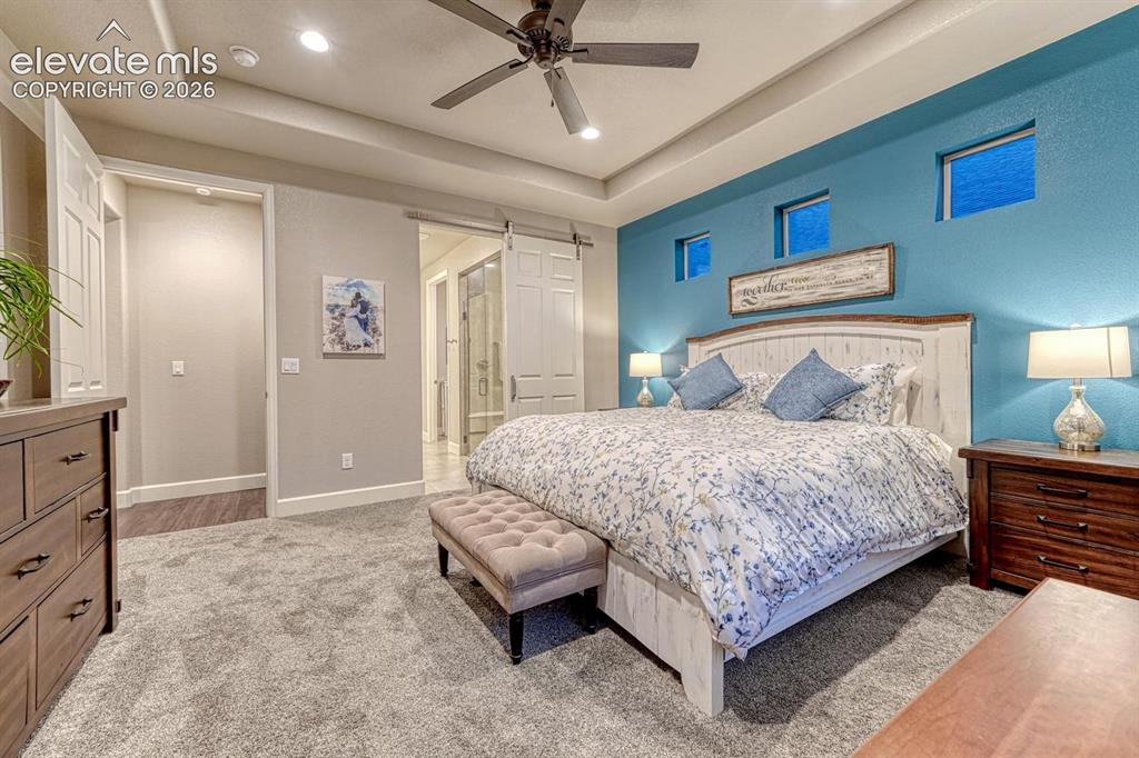 Image 13 of 44: Tray ceiling with recessed lighting and a ceiling fan