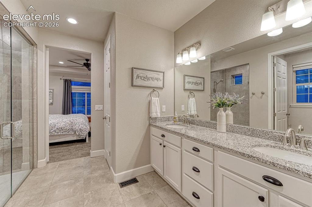 Image 15 of 44: Double vanity with granite-style countertop, dual undermount sinks, and con