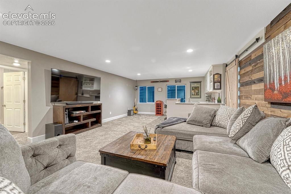 Image 20 of 44: Carpeted living area with recessed lighting, a built-in media console, and 