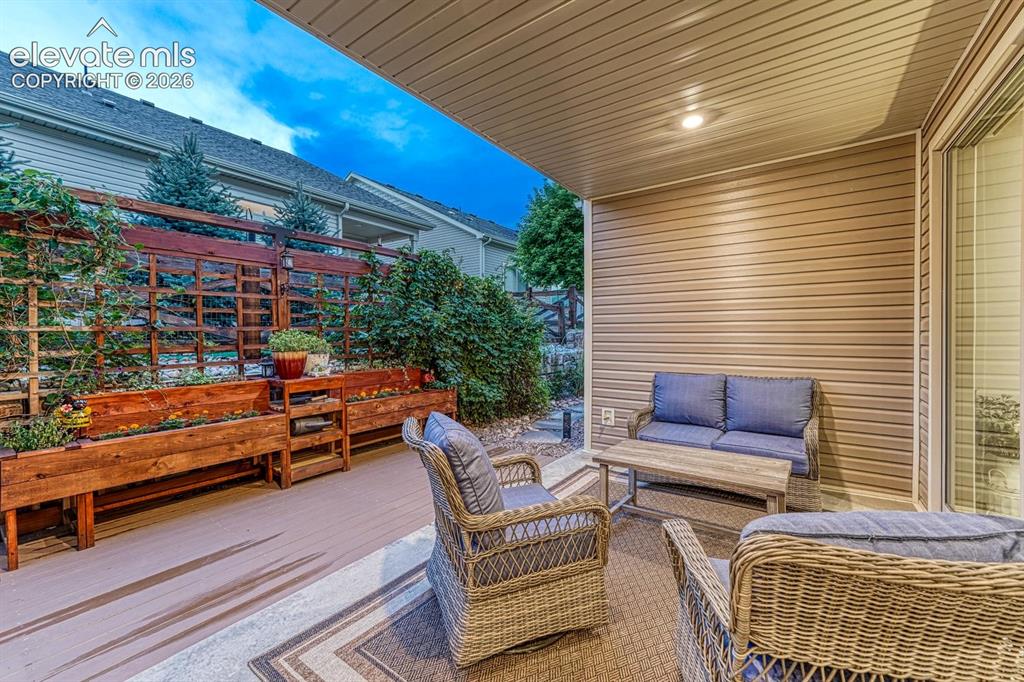 Image 29 of 44: Covered patio with integrated lighting, wood-finish decking, and built-in p