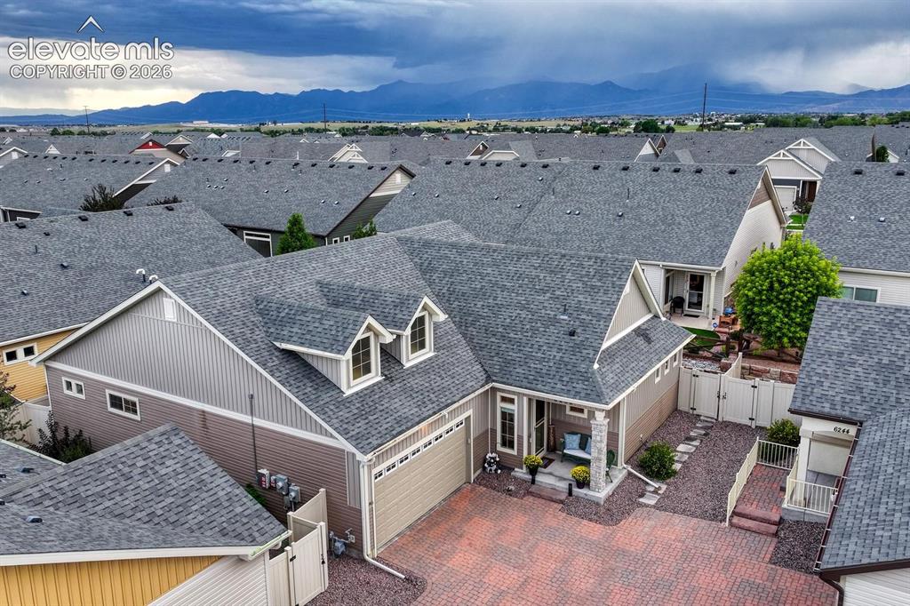 Image 31 of 44: Mountain backdrop, Shingle roofing with installed solar panels brick drivew