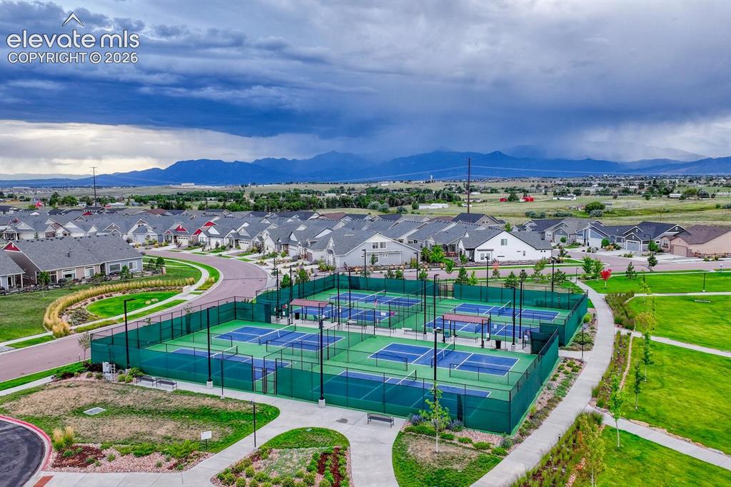 Image 38 of 44: Community sports courts with multiple playing surfaces, surrounded by green