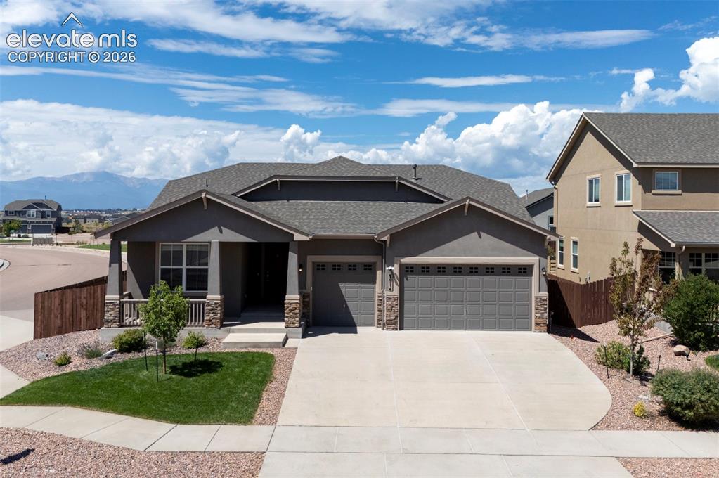 Caption: Contemporary ranch-style residence featuring a stucco exterior with stone accents and an attached th