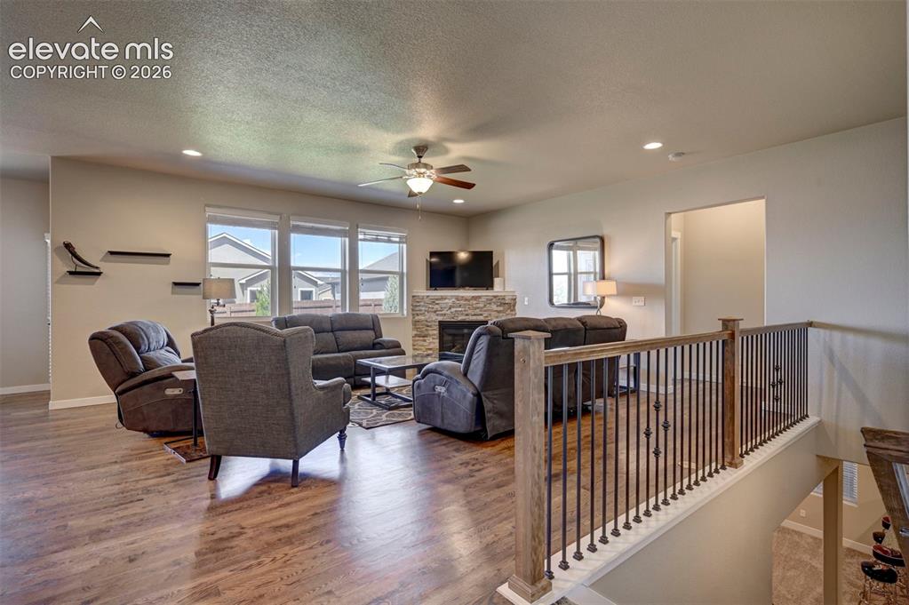 Image 11 of 40: Wood-finish flooring, recessed lighting, and a ceiling fan with integrated 