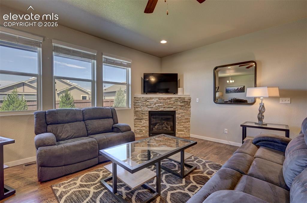 Image 12 of 40: Stacked stone fireplace with mantel, recessed lighting, wood-finish floorin