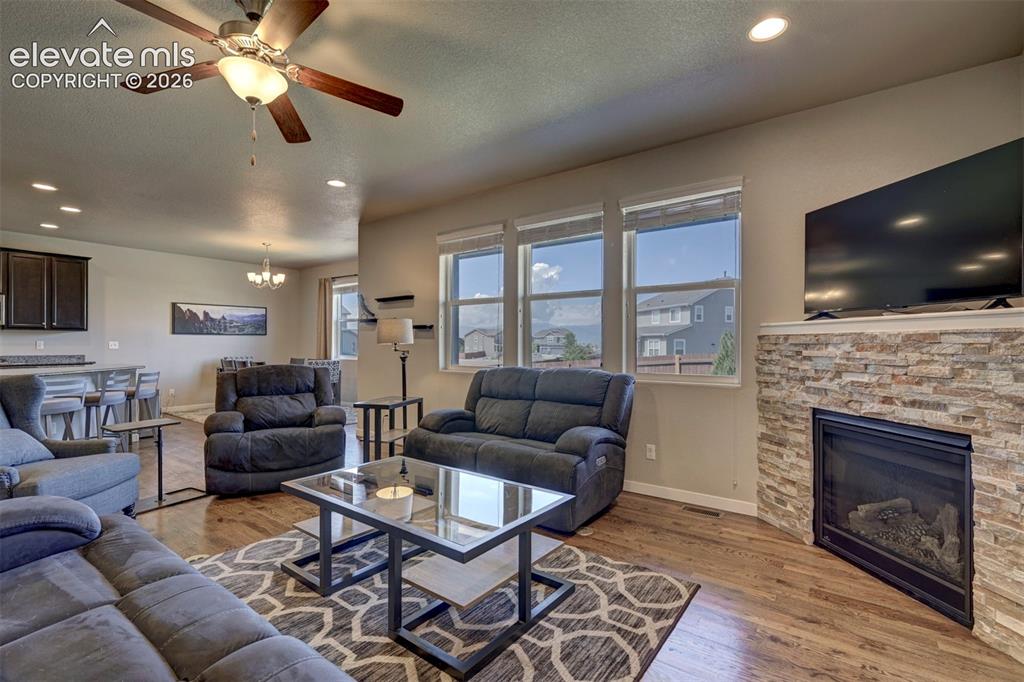 Image 14 of 40: Living area featuring a stacked stone fireplace with a built-in hearth, woo