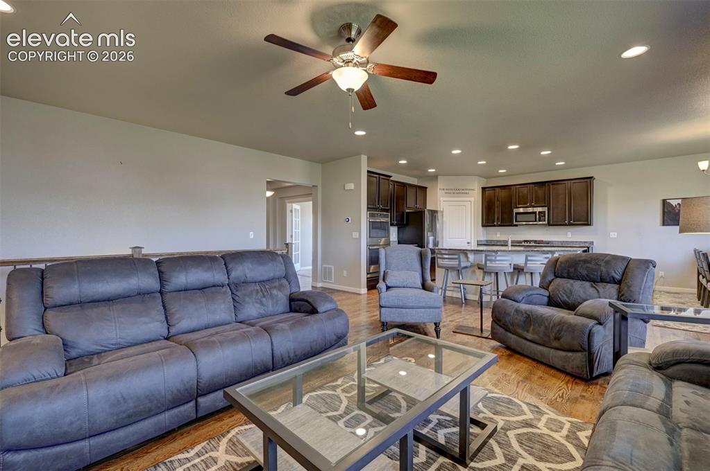 Image 15 of 40: Wood-finish flooring, recessed lighting, and a ceiling fan