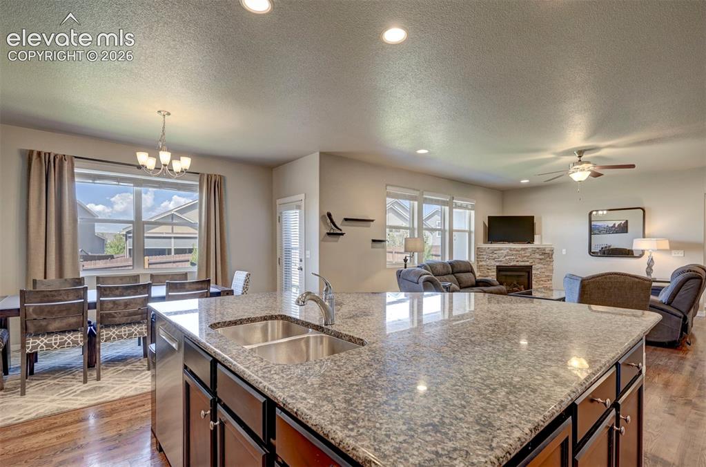 Image 17 of 40: Kitchen island with dual stainless steel sink, wood-finish flooring, recess