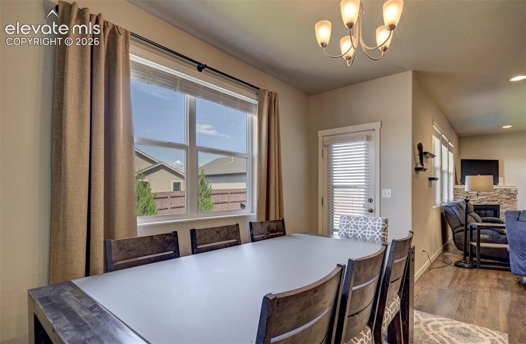 Image 21 of 40: Illuminated dining area featuring a multi-pane window, suspended chandelier