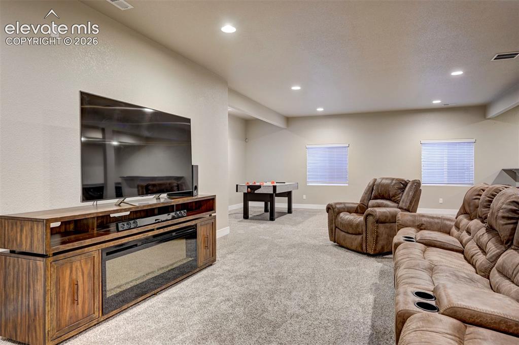 Image 33 of 40: Spacious room featuring neutral-toned walls, recessed lighting, and soft gr