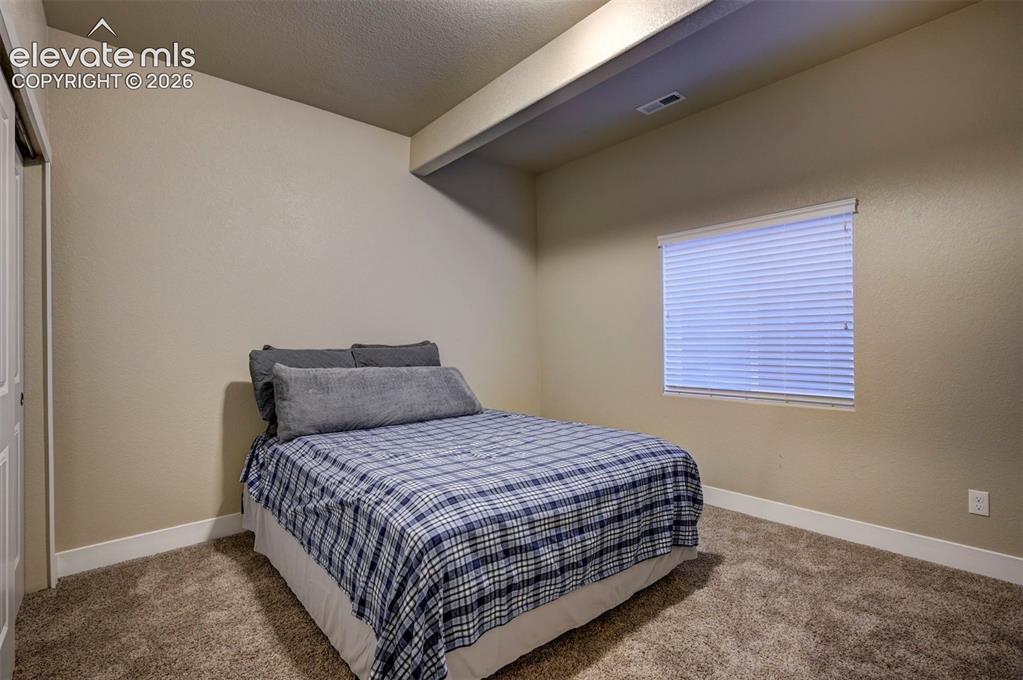 Image 34 of 40: Plush carpeting, neutral wall finishes, and a single window with blinds